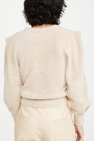  The Carina Top designed by Ronny Kobo features a cozy neutral sand fuzzy eyelash knit, classic crewneck, and on-trend puffy shoulders. Pair with your favourite high-waisted pants or denim! 