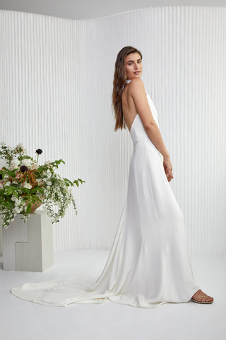 Our take on Ms. Markel's famous evening-wear inspired wedding look, relaxed, sexy, and chic. We offered this structured silk satin dress that beautifully skims the figure and comes finished with pearl & gold buttons.  This Markel gown is a super stylish classic yet sexy backless dress that is sure to make a statement wherever you decide to host your wedding event.
