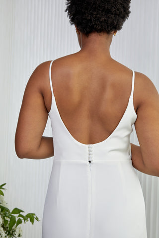 If you ever wanted a slip style wedding dress, but feel like you still want more?! Well meet Hutton, she is our take on a slightly more structured slip in Crepe. She is a form-fitting silhouette featuring a deep V back and dramatic train. The straps add a delicate touch to this beauty, accented with right amount of silk covered buttons!