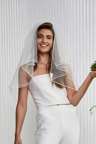 Want to really feel like a bride, but not like you're a mob bosses daughter getting married in a cathedral!? Meet Mini...the sweetest satin trim tulle veil you'll ever wear. She has 2 layers of frill that hits just below shoulder length. (30" in length)