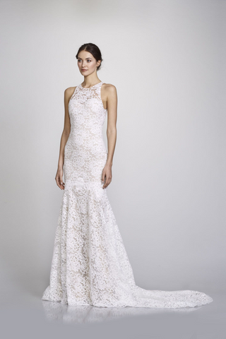 Our Sarah gown features a romantic fit and flare silhouette (hugging you in all the right places), with a timeless sheer high neck. Designed by Theia in an off-white soft cotton lace with an elegant chapel length train. This is a sample sale gown in excellent condition. 