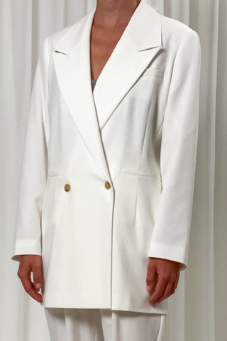 Birgitte Herskind's oversized blazer will instantly become a wardrobe staple because it's so versatile. It's made from 100% recycled polyester in a double-breasted silhouette that's tailored with wide peak lapels and padded shoulders. Wear yours with matching Brenda pants in Off White. A statement outfit for your wedding or any wedding event. 