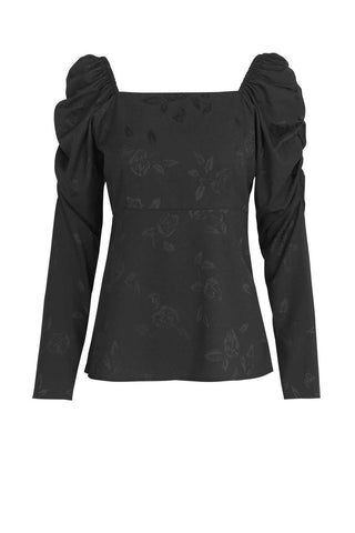 A black feminine blouse with a squared neckline and puff sleeves in a cool rose weaved fabric. Made from 100% recycled polyester made from plastic waste. Cras only uses certified sustainable and natural fabrics, which reduces the footprint of our products immensely. The fabrics range from certified recycled polyester, the new “green“ type of viscose Eco Vero, natural silk and organic cotton. 