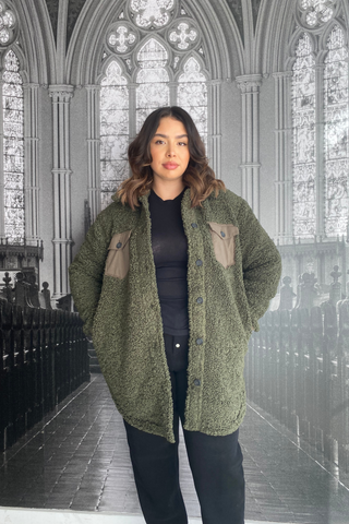 No winter wardrobe is complete without a cozy lounge coat. Wrap yourself up in this mid-length coat jacket, featuring a classic collar, straight silhouette, front beige-olive pockets and black buttons up the front. Designed by Just Female. 