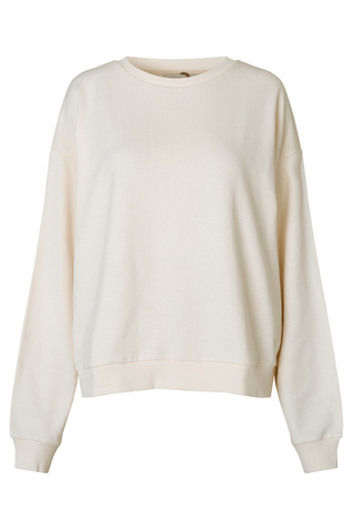 A neutral oversized crewneck sweater in an off-white colour, made of soft organic cotton. The sweater has a round neck and dropped shoulders, and rib edges. Designed by Just Female, style it with our Wish Pants or anything from our Lounge Collection for a cozy casual look. 