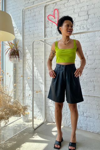 A statement piece for your next summer outing. Elevate your shorts game with the Bermuda Short featuring a high waist and casual pleats made from a polyblend faux leather. This is a classic look designed by Pastiche in black - perfect for any summer or holiday wardrobe. 