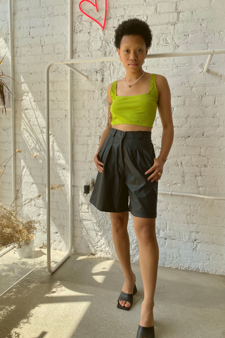 A statement piece for your next summer outing. Elevate your shorts game with the Bermuda Short featuring a high waist and casual pleats made from a polyblend faux leather. This is a classic look designed by Pastiche in black - perfect for any summer or holiday wardrobe. 