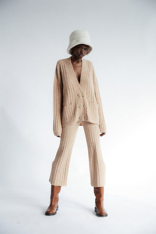 Looking for the perfect cardigan for the colder months ahead? Look no further. The Amira Knit is an oversized cardigan with a relaxed fit for all of your layering combinations. In a classic black with buttons down the front. Available in both tan and black. Designed by TACH Clothing, and made from an alpaca wool blend.   DETAILS:  28% Superfine Alpaca, 10% Wool, 61% Poliamidic Fiber, 1% Elastano SIZE + FIT:  Oversized 